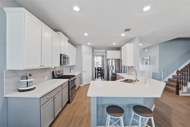 kitchen with a sink, a kitchen breakfast bar, tasteful backsplash, stainless steel appliances, and a peninsula