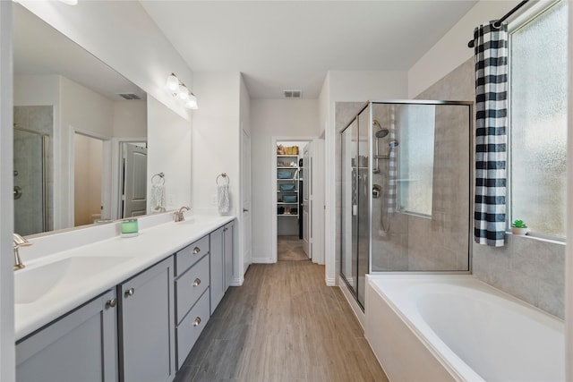 bathroom with a sink, visible vents, and a shower stall