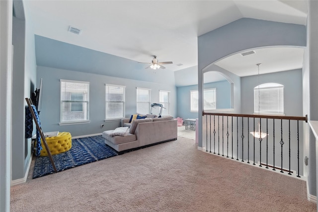 living area with visible vents, carpet floors, ceiling fan, and vaulted ceiling