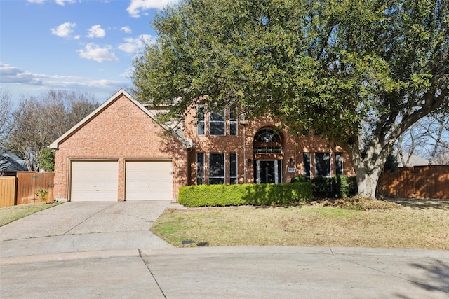 view of front of property with fence, concrete driveway, a front yard, an attached garage, and brick siding