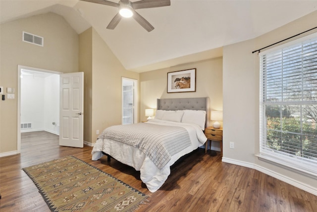 bedroom with visible vents, wood finished floors, baseboards, and vaulted ceiling