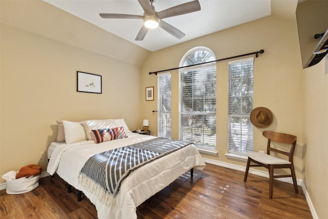 bedroom with vaulted ceiling, multiple windows, wood finished floors, and baseboards