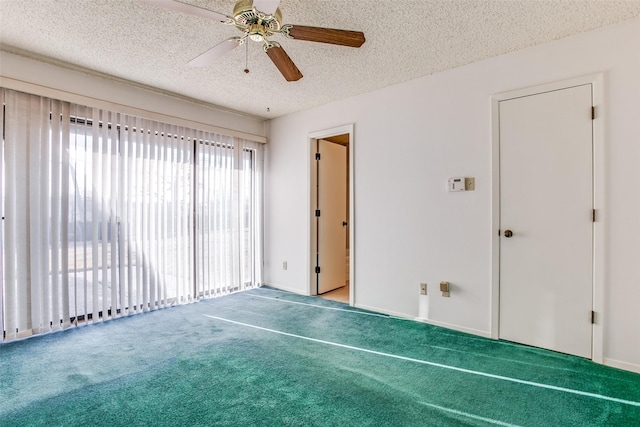 spare room with a textured ceiling, a ceiling fan, and carpet