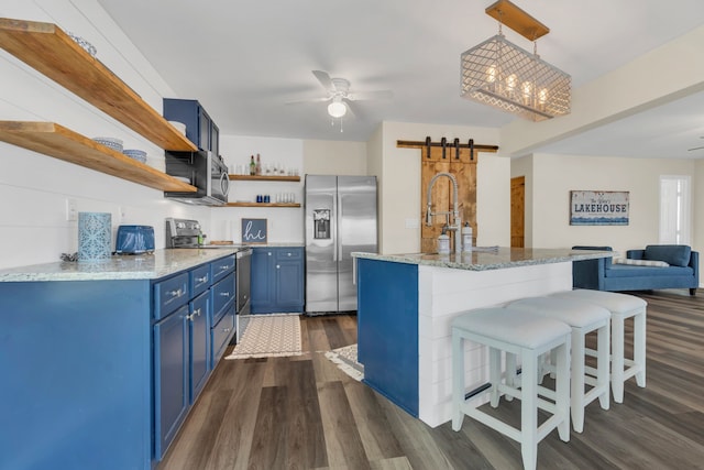 kitchen with a breakfast bar, a ceiling fan, blue cabinetry, open shelves, and appliances with stainless steel finishes