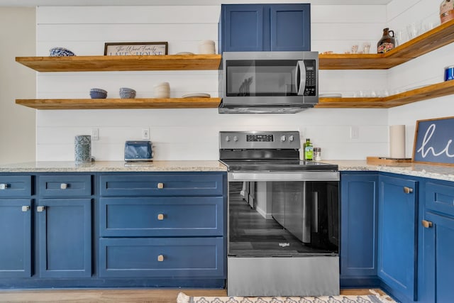 kitchen featuring light stone countertops, stainless steel appliances, blue cabinets, and open shelves