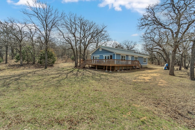 back of property featuring a yard and a wooden deck