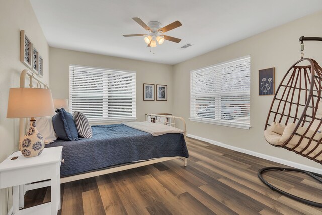 bedroom featuring visible vents, ceiling fan, baseboards, and wood finished floors