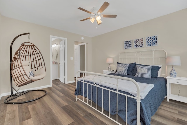 bedroom with a ceiling fan, wood finished floors, baseboards, and ensuite bathroom