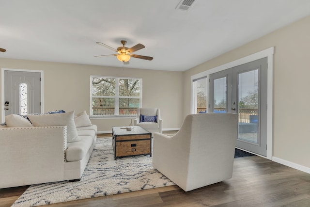 living area with visible vents, wood finished floors, french doors, baseboards, and ceiling fan