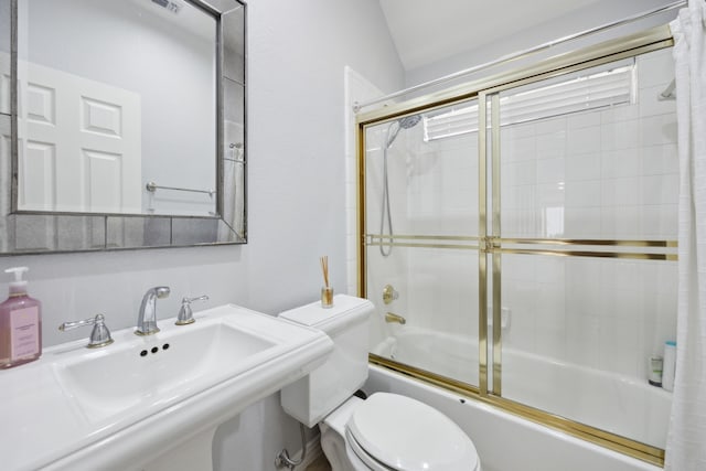 bathroom featuring toilet, visible vents, bath / shower combo with glass door, and a sink