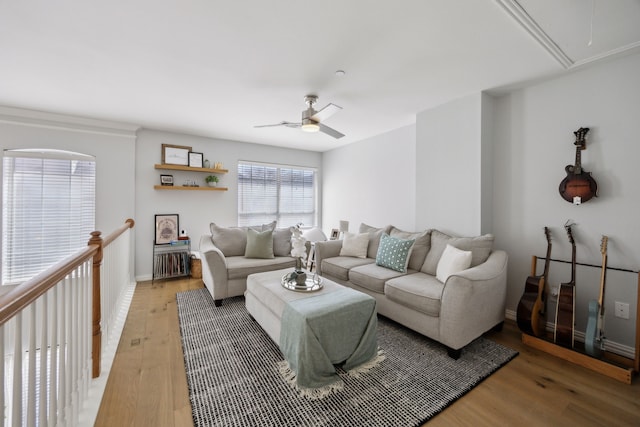 living area featuring baseboards, light wood-style flooring, attic access, and ceiling fan