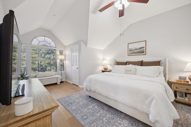 bedroom with light wood-style flooring, baseboards, a ceiling fan, and vaulted ceiling