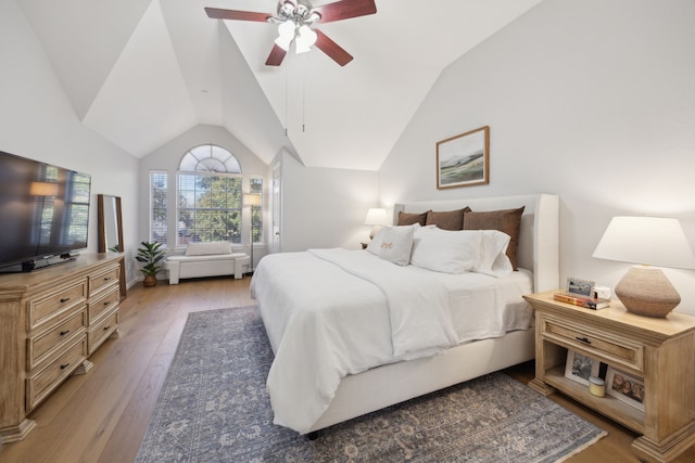 bedroom featuring ceiling fan, light wood-style flooring, and vaulted ceiling