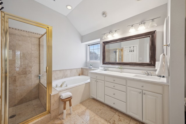 full bathroom with a garden tub, double vanity, vaulted ceiling, a stall shower, and a sink