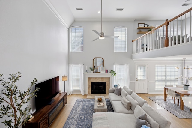 living room featuring visible vents, a ceiling fan, and light wood-style floors