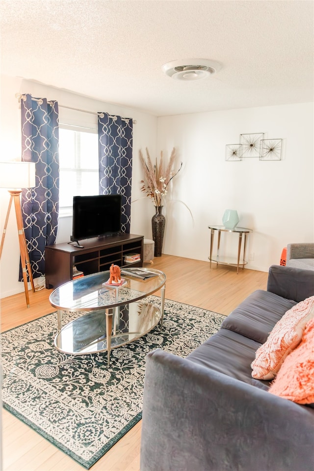 living area with wood finished floors and a textured ceiling