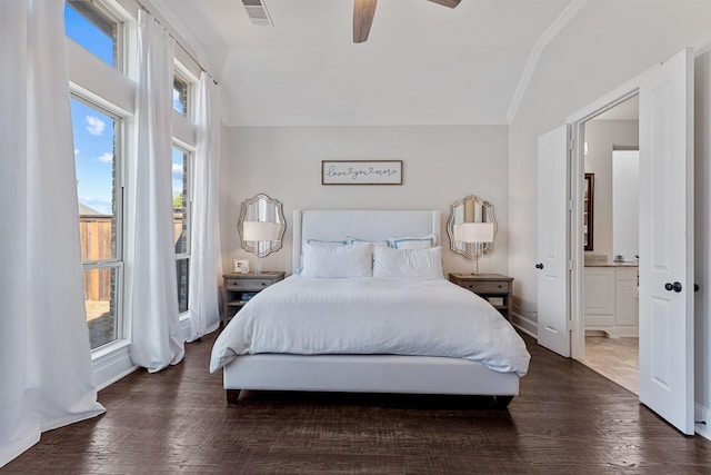 bedroom featuring visible vents, ornamental molding, ensuite bathroom, wood finished floors, and lofted ceiling