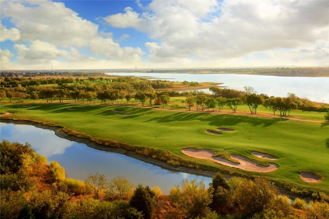 view of property's community featuring golf course view, a yard, and a water view