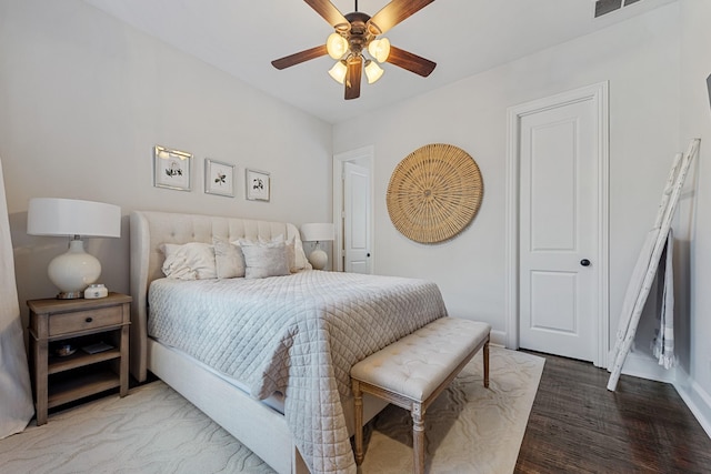 bedroom with a ceiling fan, wood finished floors, and baseboards