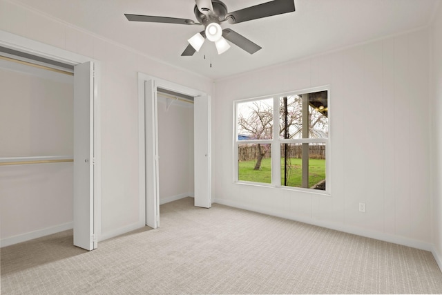 unfurnished bedroom with baseboards, carpet, ceiling fan, and crown molding