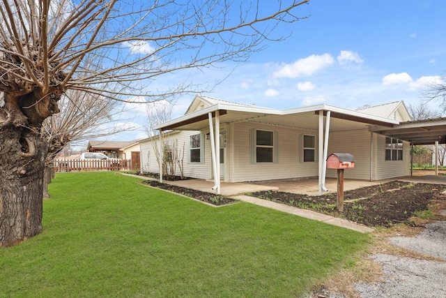 view of home's exterior featuring a carport, a yard, and fence