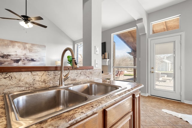 kitchen featuring light tile patterned flooring, plenty of natural light, lofted ceiling, and a sink