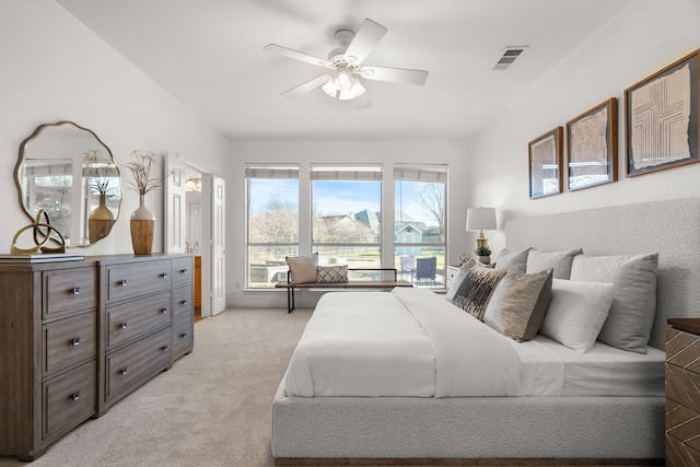 bedroom with visible vents, light colored carpet, and ceiling fan