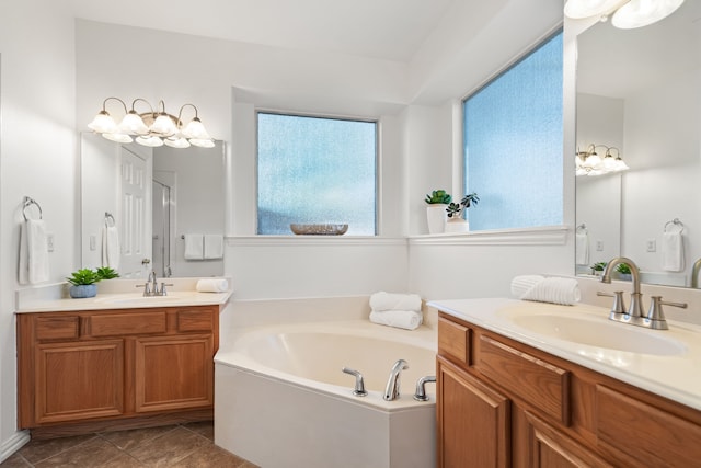 bathroom featuring a sink, two vanities, a bath, and tile patterned flooring