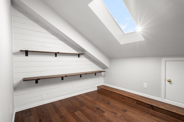 additional living space with a skylight and dark wood-style flooring