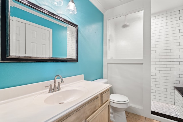 bathroom with vanity, tile patterned floors, toilet, and a tile shower