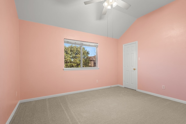 empty room with a ceiling fan, vaulted ceiling, carpet, and baseboards