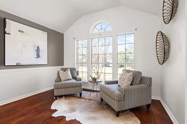 living area featuring baseboards, lofted ceiling, and wood finished floors