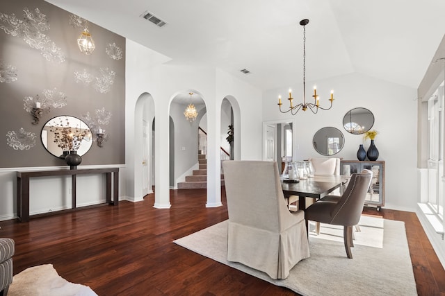 dining area with visible vents, lofted ceiling, wood finished floors, arched walkways, and a notable chandelier