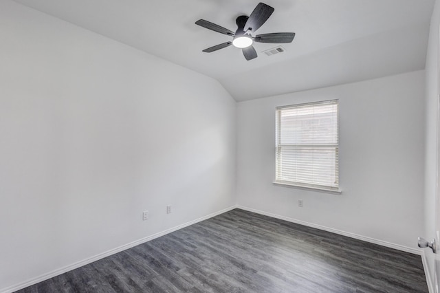 empty room with baseboards, visible vents, lofted ceiling, dark wood-style flooring, and ceiling fan