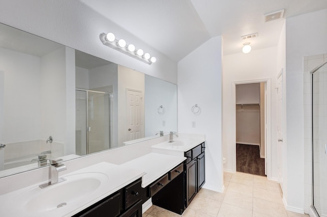 full bath with double vanity, visible vents, a stall shower, and a sink