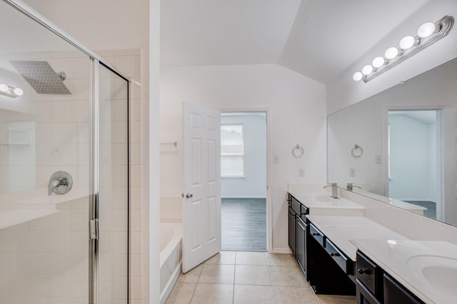 bathroom featuring tile patterned floors, a shower stall, lofted ceiling, and double vanity