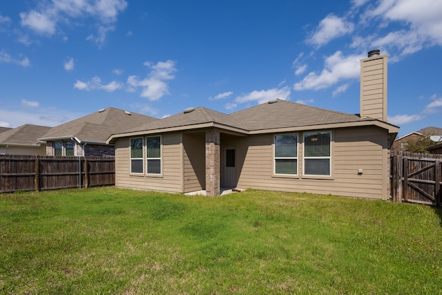 back of property featuring a lawn, a fenced backyard, a chimney, and a gate