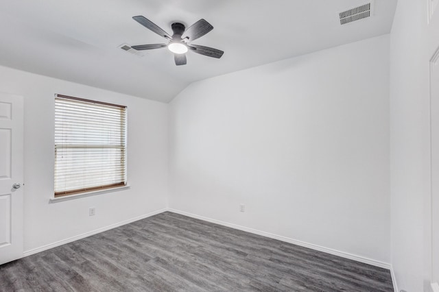 spare room with vaulted ceiling, visible vents, a ceiling fan, and dark wood-style flooring