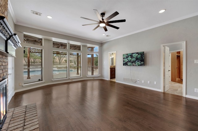 unfurnished living room with crown molding, baseboards, a fireplace, wood finished floors, and a ceiling fan