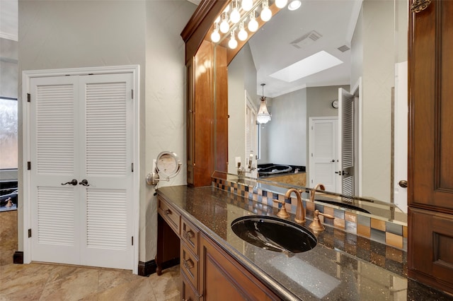 bathroom featuring a closet, visible vents, a skylight, and vanity