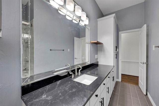 bathroom with a shower, baseboards, wood finished floors, and vanity