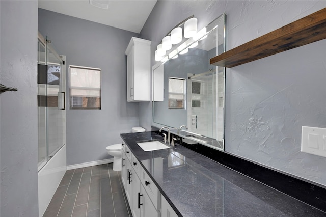 full bath featuring vanity, toilet, baseboards, and combined bath / shower with glass door