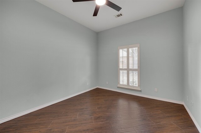 empty room featuring dark wood-style floors, visible vents, baseboards, and ceiling fan