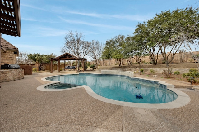 view of pool featuring a pool with connected hot tub, a gazebo, a fenced backyard, an outdoor kitchen, and a patio