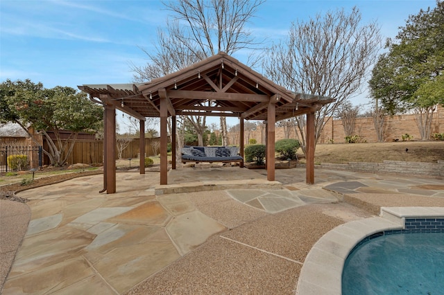 view of patio / terrace with fence, a fenced in pool, and a gazebo