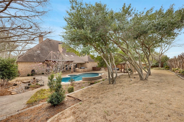 outdoor pool with a patio area and fence