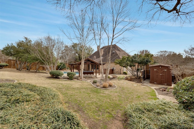 view of yard with an outbuilding, a fenced in pool, a shed, a fenced backyard, and a gazebo