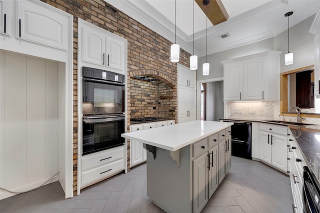 kitchen with black appliances, ornamental molding, visible vents, and a sink