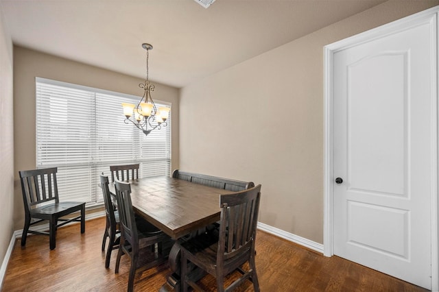 dining room featuring baseboards, a chandelier, and dark wood-style flooring