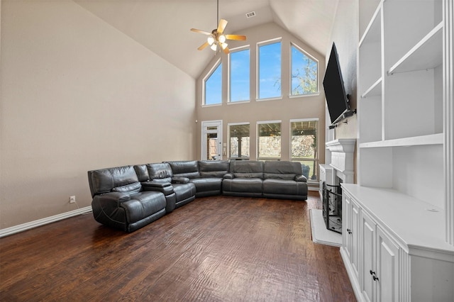 living area featuring dark wood-type flooring, baseboards, ceiling fan, a fireplace, and high vaulted ceiling